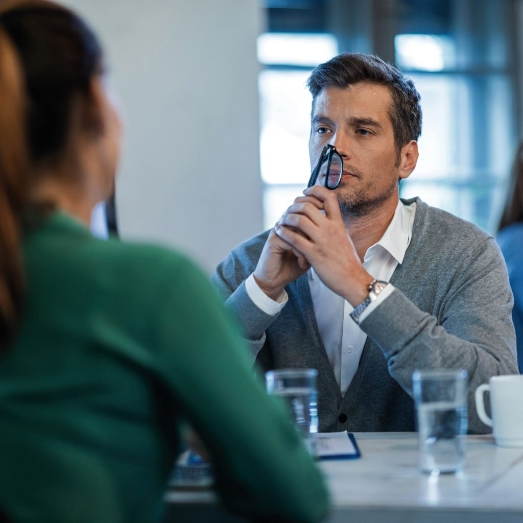 Un manager et une collaboratrice en entretien de feedback, assis face à face dans un bureau